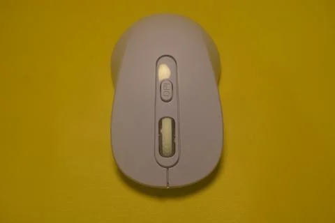 A purple wireless computer mouse isolated on yellow background Stock Photos