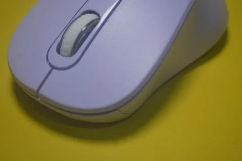 A purple wireless computer mouse isolated on yellow background Stock Photos