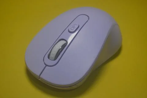 A purple wireless computer mouse isolated on yellow background Stock Photos