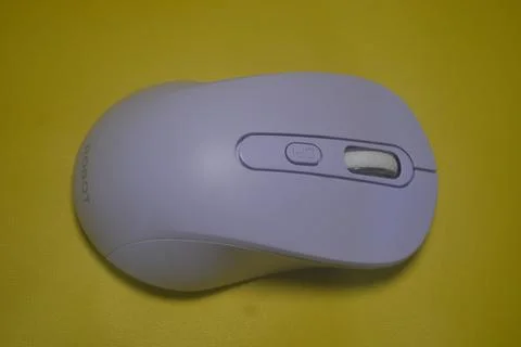 A purple wireless computer mouse isolated on yellow background Stock Photos