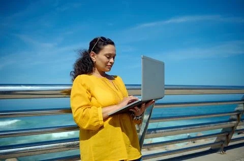 Purposeful female developer, trader, manager online working on laptop outdoor Stock Photos