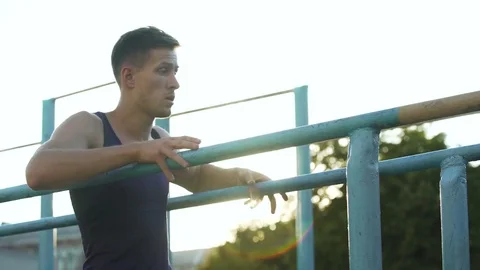 Purposeful young male doing exercises on parallel crossbars outdoors, sport Video stock 83065657