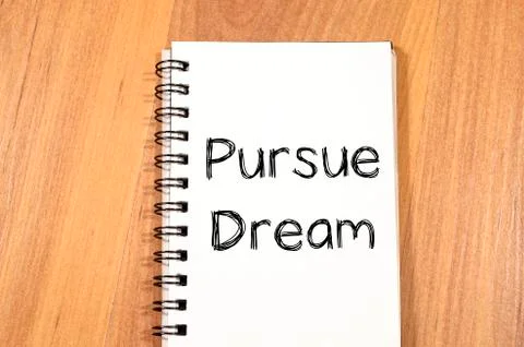 Pursue dream write on notebook Stock Photos
