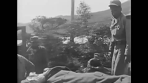 PUSAN - 1950 - Nurses and doctors transfer wounded soldiers into an ambulance Stock Footage 280068010