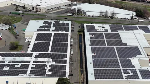 Push-in aerial descending toward rooftop solar arrays, Jersey City Vídeo Stock 344597476