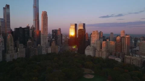 Push in aerial over a pond toward Central Park Tower at sunrise Vídeo Stock 344593564