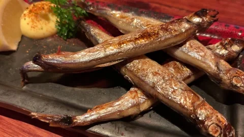 Push In and Circular Shot of Grilled Shishamo Fish with Crispy Skin Stock Footage 333472297