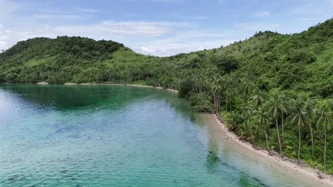 Push-in and panning drone shot following the curved shoreline of an island in Stock Footage 336681327
