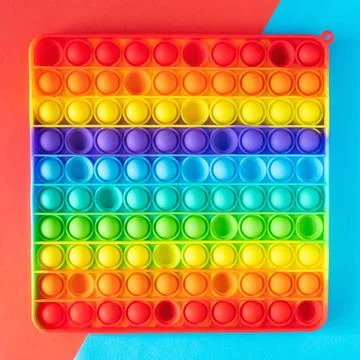 Push Bubble Fidget Toy Pop It on colorful background. Stock Photos