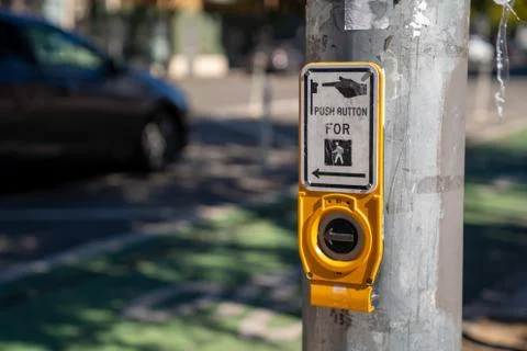 Push button cross walk intersection on light post with sign Foto stock
