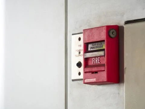 Push button switch, fire alarm on grey wall for alarm and security system wit Foto stock