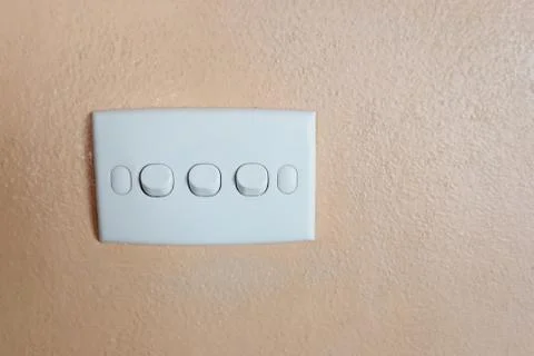 Push button of white switch on orange wall. Stock Photos