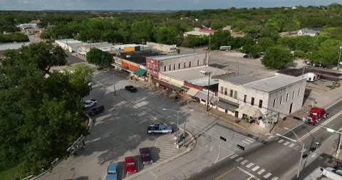 Push in descending flight viewing a city block of retail stores and businesses Stock Footage 221114106