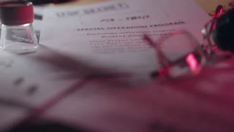 Push in on document titled TOP SECRET laying next to other classified papers Stock Footage 199971593