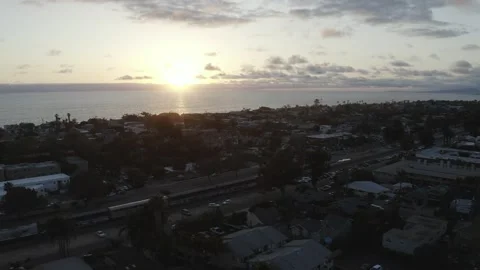 Push in by drone of a train passing by at sunset with beach behind Stockbeeldmateriaal 167676291