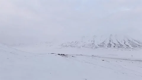 Push Forward Aerial Approaching Svalbard Seed Vault in Snowy Fog Reflecting Stock Footage 345526762