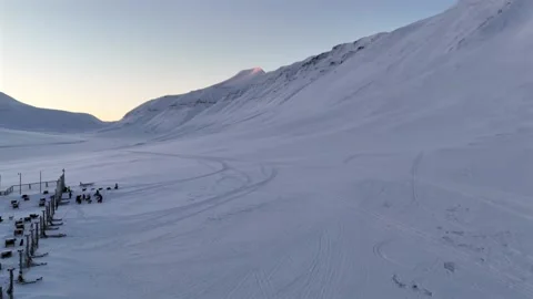 Push Forward Aerial From Dog Sledding Station Across Svalbard Snowfield Evoking Stock Footage 345527286