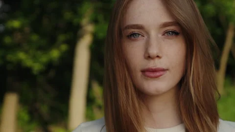Push out scene of a beautiful red haired woman with freckles looking at camera Stock Footage 245752242