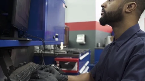 Push-out shot of a mechanic using a computer 動画素材 76232936