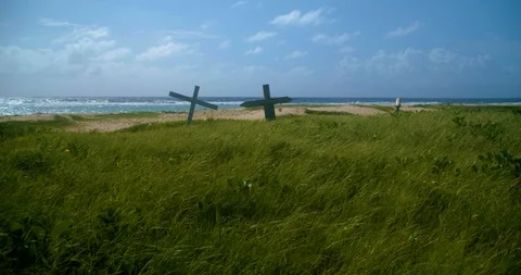 A push out shot of two crosses on a small beach hill Stock-Footage 98432938