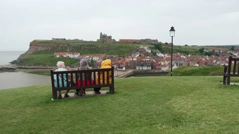 Push out shot of Whitby with three retired women sat on bench Stock Footage 197518222