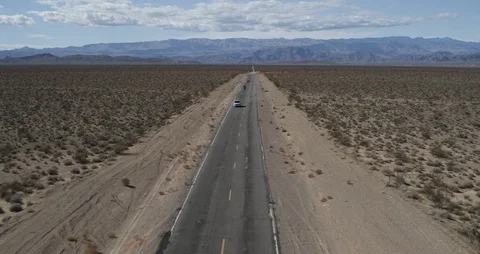 Push Over Desert Highway to tilt down as motorcycles pass under Stock Footage 107577569