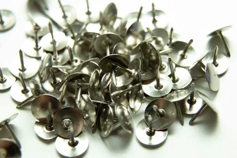Push pins on a white background. Colored and silver buttons. Many and one. Bl Stock Photos