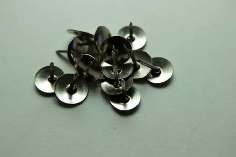 Push pins on a white background. Colored and silver buttons. Many and one. Bl Stock Photos