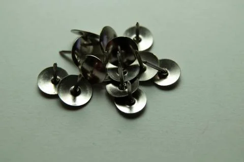 Push pins on a white background. Colored and silver buttons. Many and one. Bl Stock Photos