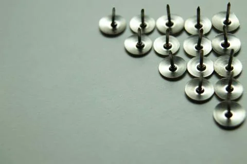 Push pins on a white background. Colored and silver buttons. Many and one. Bl Stock Photos