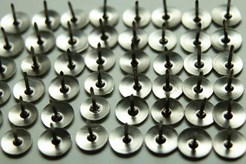 Push pins on a white background. Colored and silver buttons. Many and one. Bl Stock Photos
