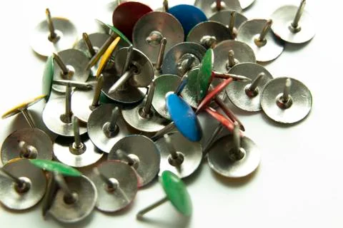 Push pins on a white background. Colored and silver buttons. Many and one. Bl Stock Photos