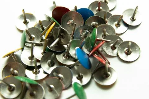 Push pins on a white background. Colored and silver buttons. Many and one. Bl Stock Photos