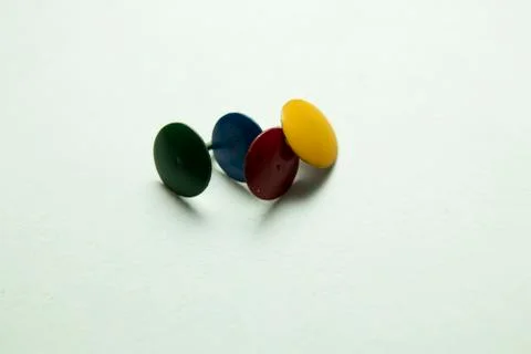 Push pins on a white background. Colored and silver buttons. Many and one. Bl Stock Photos
