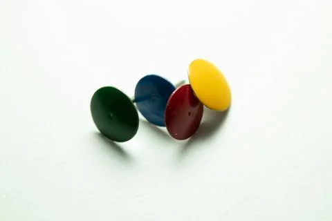 Push pins on a white background. Colored and silver buttons. Many and one. Bl Stock Photos