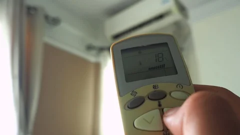 Push the remote button air conditioner for increed temperature from 18 to 20 库存影片 111054678