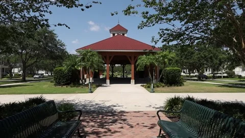Push in shot to gazebo through pathway and trees Video stock 245452591