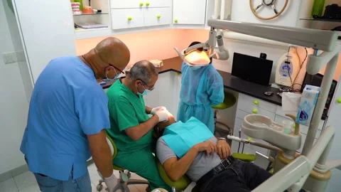 Push in shot showing doctors and nurses observing a dental procedure Stock Footage 244623681