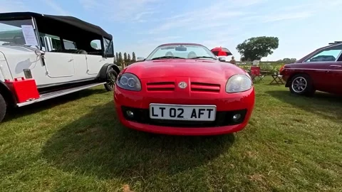 Push in shot towards a bright red MGTF sports car Video stock 250276409