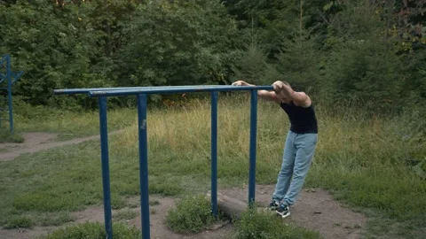 Push-ups on bars with a straight body after warm-up. Street workout classes Stock Footage 157998000