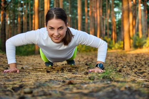 Push ups or press ups exercise by young woman. Stock Photos