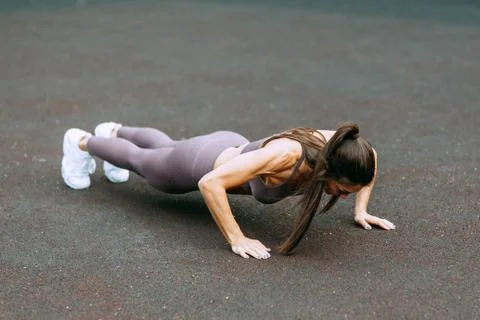 Push-UPS, workout and plank on the street. Beautiful athletic girl on the Pla Foto stock