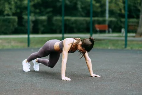 Push-UPS, workout and plank on the street. Beautiful athletic girl on the Pla Stock Photos