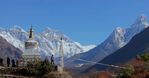Push in view of Namche Bazaar Nepal showing man standing near Buddhist stupa Stockbeeldmateriaal 337395766
