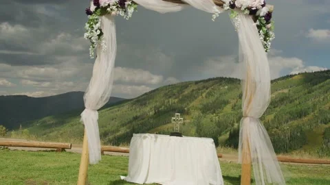 Push in on wedding alter and cross in Colorado mountains in summer 스톡 동영상 235381119