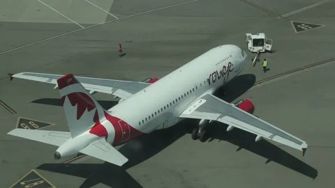Pushback Tractor Disengages from Air Canada Rouge Plane Destined for Runway Stock Footage 219707058