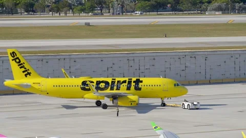 Pushback tractor or airport tug pushing back a Spirit airplane 스톡 동영상 304298070