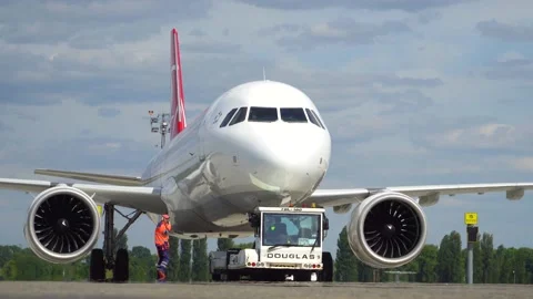 The pushback tractor is towing the aircraft away from the parking lot. Kyiv Video stock 182075672