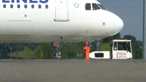 The pushback tractor is towing the aircraft away from the parking lot. Kyiv Video stock 182115751