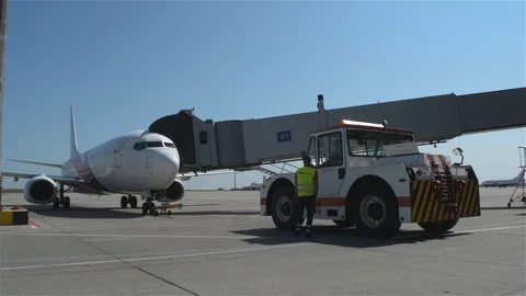 Pushback tug stays in front of jet plane Stock Footage 94005176